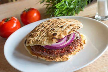 Tasty Serbian hamburger in pita bread with fresh salad ingredients