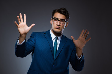 Businessman pressing virtual buttons on gray background