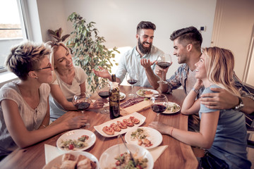 Group of  friends enjoying meal at home together