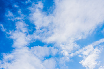 Obraz premium Blue sky with white cirrus clouds, illuminated by the sun and trace from airplane