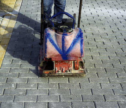 Vibrator with rubber plate for compacting paving with interlocking blocks
