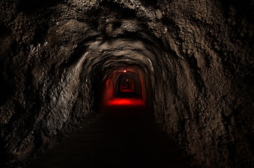 Infinite tunnel with an ominous red backlight through the rock