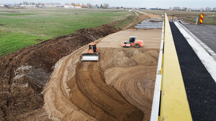 Bulldozer and compactor on construction site