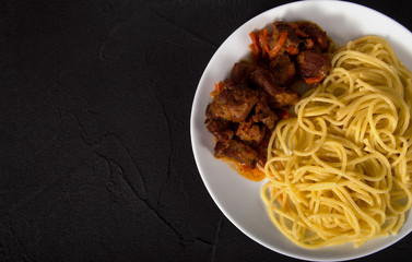 Spaghetti with beef meat in white plate on dark cement background view top