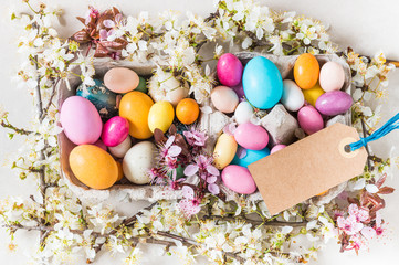 Fototapeta na wymiar Easter holiday background.Easter chocolate candy eggs and spring flowers, minimalism, modern decoration, copy space.