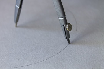 compasses draw a circle on a sheet of paper
