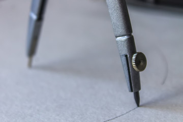 compasses draw a circle on a sheet of paper