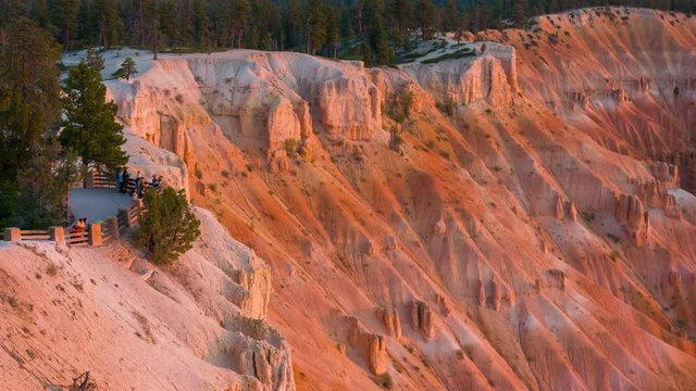 Rays of the sun illuminates orange cliffs. People make photos of breathtaking view of the canyon. Nature video. Amazing mountain landscape.Bryce Canyon National Park. Utah. USA. 4K, high bit rate, UHD
