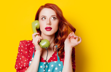 Redhead housewife with handset of dial phone