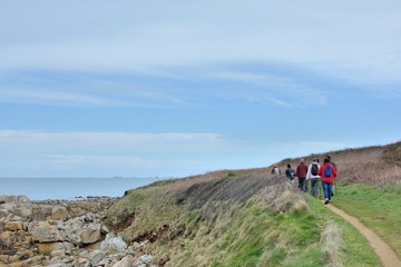 Randonneurs en bord de mer sur le GR34 en Bretagne