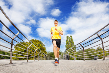 Man running sprinting across the bridge outdoors