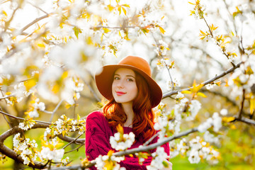 girl in red clothes in blossom cherry garden