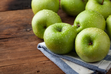 Ripe green apples in a wooden bowl on an old rustic table. Useful fruits on wooden background. with copy space