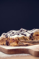 Freshly baked apple pie sprinkled with powdered sugar and topped with chocolate. Delicious homemade pastries with shallow depth of field.