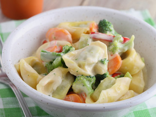 Tortellini with vegetables under cream sauce