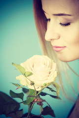 Shot on blue of woman holding white rose