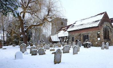 Ringmer church, East Sussex, uk the church the grave stones and grave yard in the foregeground snow on the ground and on the church