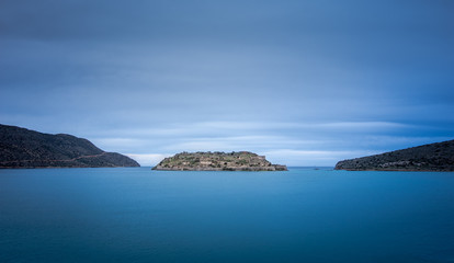View of the island of Spinalonga with calm sea. Here were isolated lepers, humans with the Hansen's desease, gulf of Elounda, Crete, Greece. 