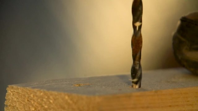 Drilling holes in a wooden bar with a drill and a hand drill with a high frame rate.