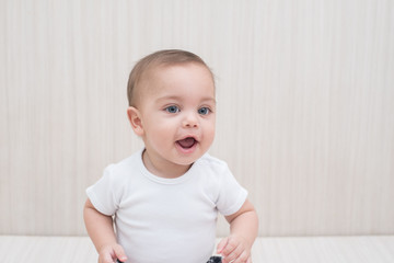 Blue-eyed baby boy on white wooden background