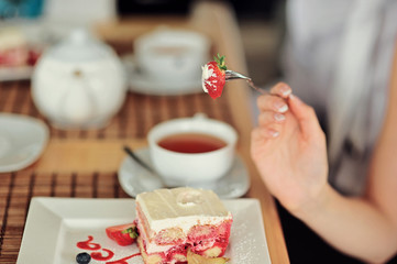 A newlywed couple drinking hot coffee or tea with sweet dessert in warm cozy cafe with wedding bouquet on the table. Atmoshere of happiness of new family and love tenderness