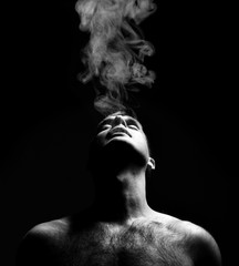 Closeup portrait of sexy handsome topless male model with smoke