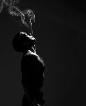 Closeup portrait of sexy handsome topless male model with smoke