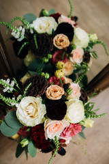 a wedding bouquet of white, red, burgundy, roses, carnations stands near the mirror on the background of its reflection