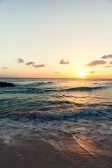 Fototapeta na wymiar Barbados Beach at Sunset, Yellow and Orange Sky, Waves