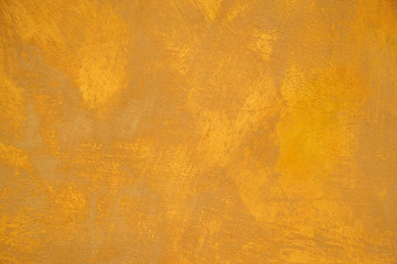 Old stucco plaster yellow painted wall abstract background texture photo