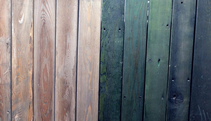 The texture of the old fence, painted in pink and dark green colors
