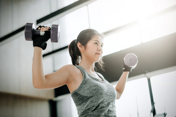 Asian woman doing exercise with dumbbell