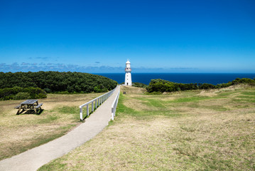 Cape Otway Lighthouse in grasslandpark with bench and overlook at the ocean at the Great Ocean Road, Victoria, Australia