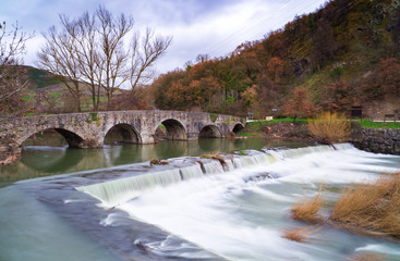 Fototapeta na wymiar The famous Trinity Bridge, with the Ulzama River as it passes through Atarrabia, Navarra, Spain