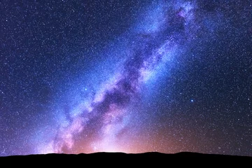 Fotobehang Milky Way. Space. Scenic night landscape with bright milky way, sky full of stars, orange light and hills. Shiny stars. Beautiful scene with universe. Space background with starry sky. Concept. Nature © den-belitsky
