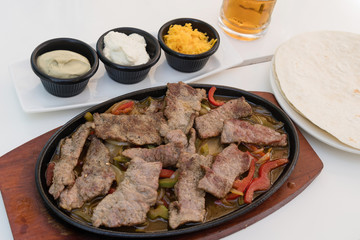 Delicious slices of roasted beef meat with red peppers served with various sauces and bread