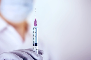Close up a medical injection syringe in hand of  doctor , medical science concept.