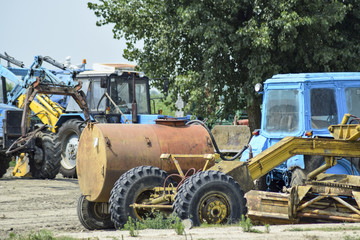 Open-air garage for agricultural machinery. Old tractors, combines and towed equipment