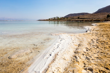 View of Dead Sea coastline. Salt crystals at sunset. Texture of Dead sea. Salty sea shore