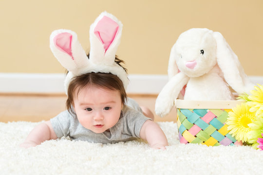 Baby boy with a stuffed rabbit celebrating Easter