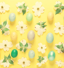 Spring flowers and Easter eggs arrangement on a yellow background
