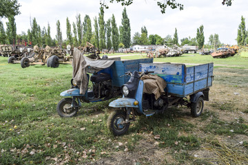 Scooter ant. Old Soviet motor scooter on three wheels with a cart