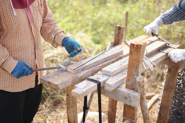 Asian worker bending metal at house construction site