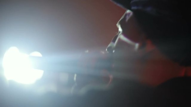 Side view of rap singer on live concert in the night club / hip-hop band singing bright light flash flare music underground musician collective festival emotional moving