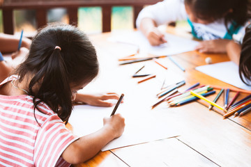Group of asian children drawing and painting with crayon together with fun