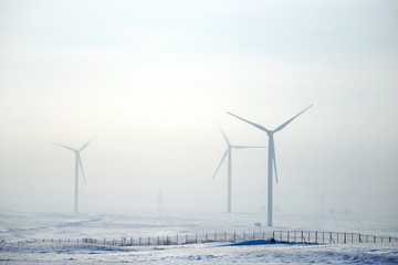 Wind power plants in winter. Wind power is the use of air flow through wind turbines to...