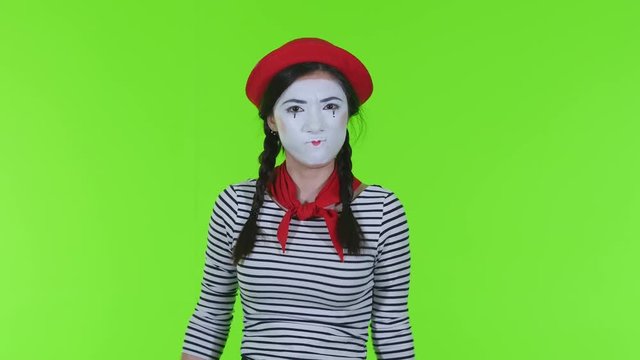 Mime girl is angry on a green background