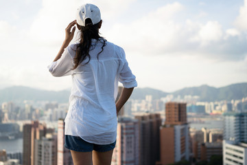 Woman standing on moutain over looking the city at sunrise