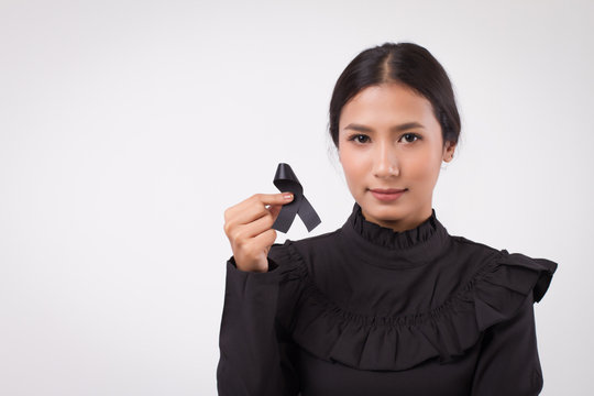 sad woman hand holding black ribbon bow, sad unhappy mourning woman, studio white isolated of asian young adult model
