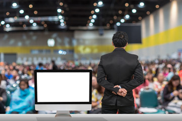 Fototapeta premium Businessman giving the knowledge with showing the white background on the computer screen over blurred photo of attendee in Exhibition Center,Business Seminar concept